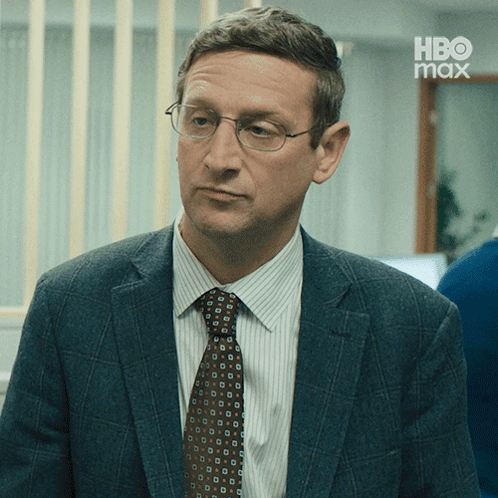 a man in a suit and tie with a hbo max logo in the background