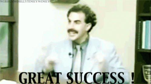 A Man In A Suit And Tie With A Mustache Says Great Success GIF