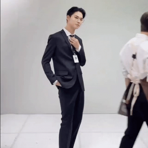 A Man In A Suit And Tie With A Name Tag That Says ' A. ' On It GIF