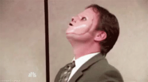 a man in a suit and tie with a red face painted on his face .