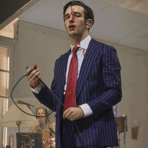 A Man In A Suit And Tie With Blood On His Face GIF