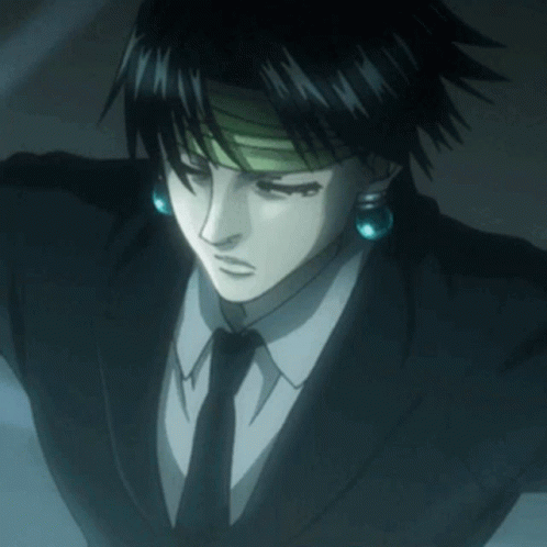 A Man In A Suit And Tie With Blue Earrings On His Ears GIF
