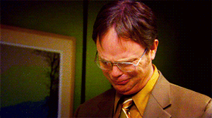 A Man In A Suit And Tie With Glasses Looks Down GIF