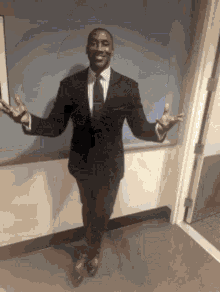 A Man In A Suit And Tie With His Arms Outstretched GIF