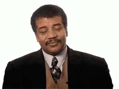 A Man In A Suit And Tie With His Eyes Closed Is Smiling . GIF