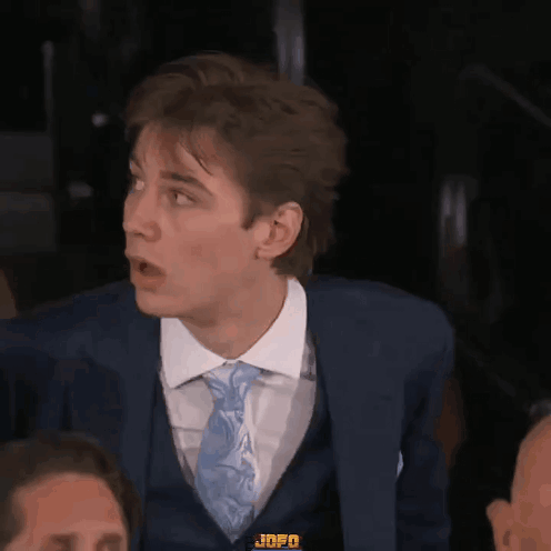 A Man In A Suit And Tie With Jnfo On His Chest GIF