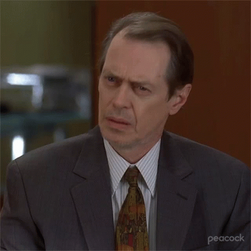 A Man In A Suit And Tie With Peacock Written On The Bottom Right Corner GIF