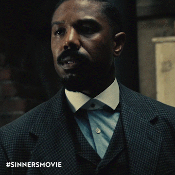 A Man In A Suit And Tie With The Hashtag #Sinnersmovie GIF