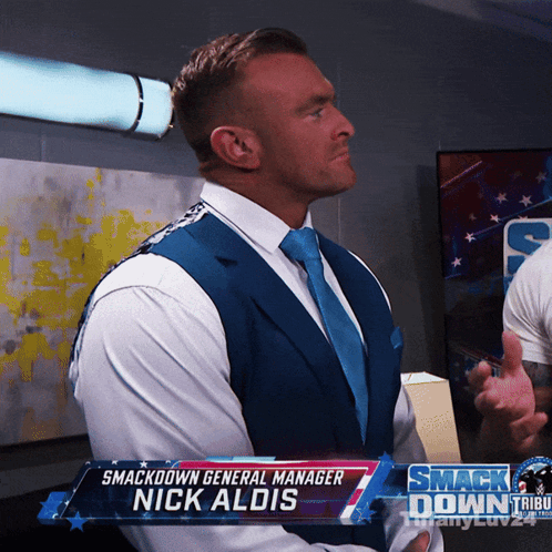 A Man In A Suit And Tie With The Name Nick Aldis GIF