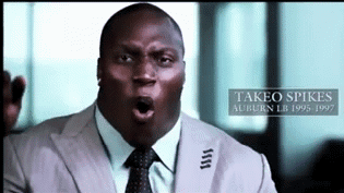 A Man In A Suit And Tie With The Name Takeo Spikes On The Bottom Right GIF