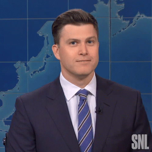A Man In A Suit And Tie With The Snl Logo On The Bottom GIF