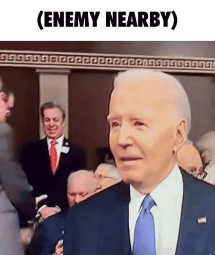 A Man In A Suit And Tie With The Words Enemy Nearby Written Below Him GIF