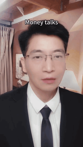A Man In A Suit And Tie With The Words Money Talks Above His Head GIF