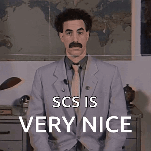 A Man In A Suit And Tie With The Words Scs Is Very Nice Above Him GIF