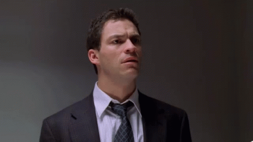 A Man In A Suit And Tie With The Words " The Fuck Did I Do " Behind Him GIF
