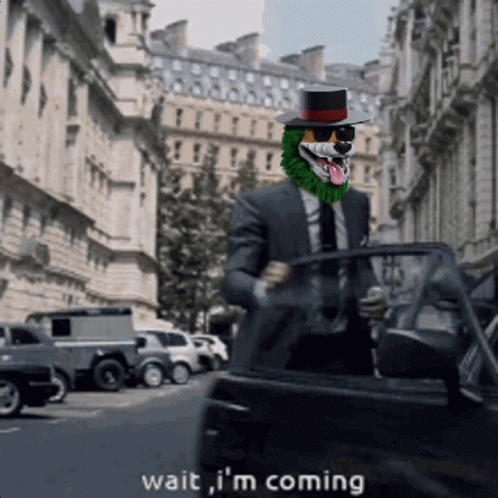 A Man In A Suit And Top Hat Says Wait I 'M Coming As He Gets Out Of A Car GIF