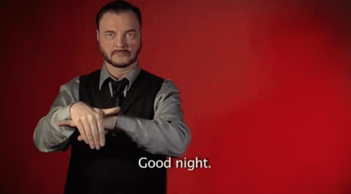 A Man In A Suit And Vest Is Making A Sign That Says Good Night GIF