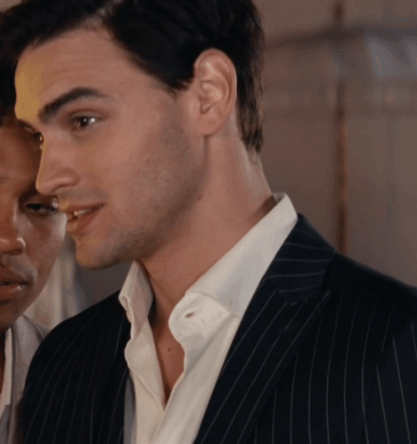 A Man In A Suit And White Shirt Is Looking At His Reflection In A Mirror GIF