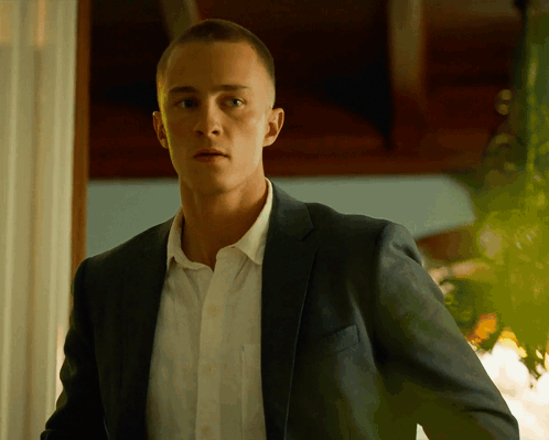 a man in a suit and white shirt is looking at the camera