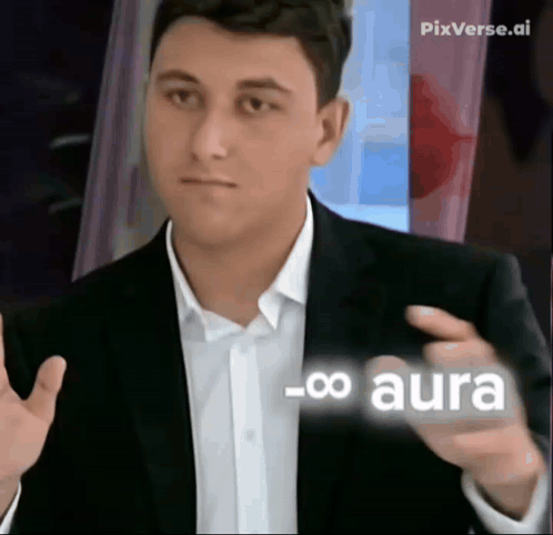 A Man In A Suit And White Shirt Is Pointing At Something With The Word Aura On It GIF