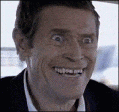A Man In A Suit And White Shirt Is Smiling With His Mouth Open . GIF
