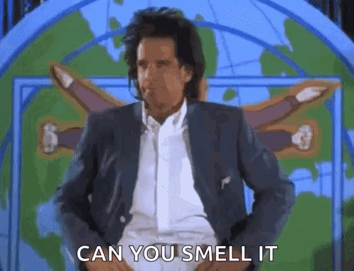A Man In A Suit And White Shirt Is Standing In Front Of A Map . GIF