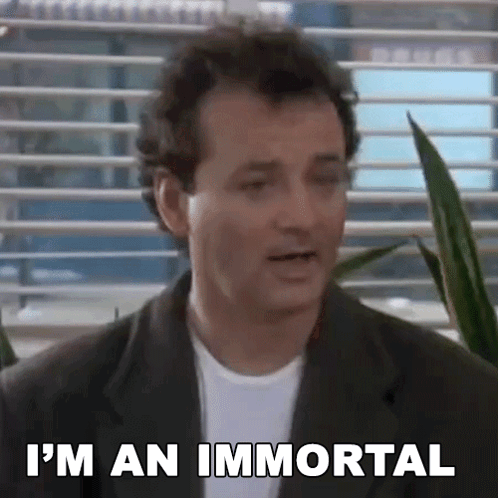 A Man In A Suit And White Shirt Is Standing In Front Of A Window And Says `` I 'M An Immortal '' . GIF