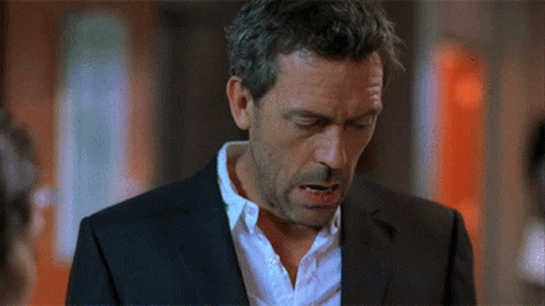 A Man In A Suit And White Shirt Looks Down With His Eyes Closed GIF