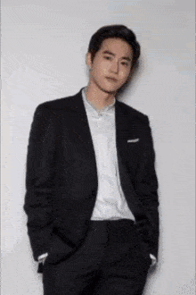 A Man In A Suit And White Shirt With His Hands In His Pockets . GIF