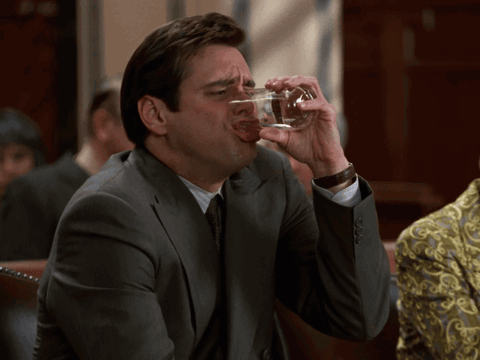 A Man In A Suit Drinks From A Glass GIF