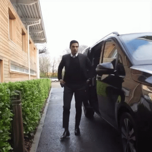 A Man In A Suit Getting Out Of A Car GIF