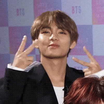 A Man In A Suit Giving A Peace Sign GIF