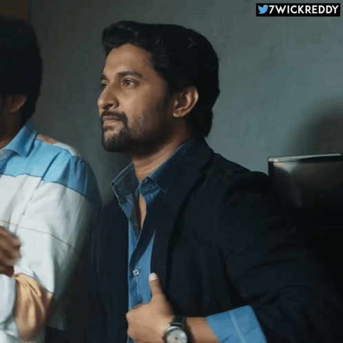 A Man In A Suit Giving A Thumbs Up Next To A Twitter Logo That Says 7Wickreddy GIF