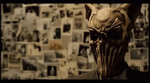 A Man In A Suit Has A Mask On His Face GIF