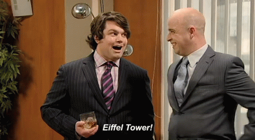 A Man In A Suit Holds A Glass Of Whiskey And Says " Eiffel Tower " GIF