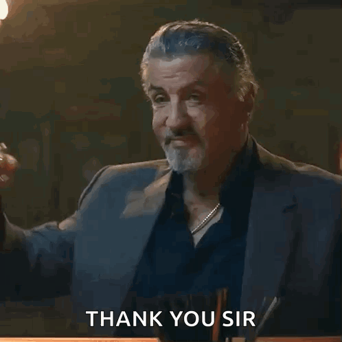 A Man In A Suit Holds A Glass Of Whiskey And Says Thank You Sir GIF