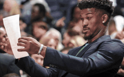 A Man In A Suit Holds A Piece Of Paper In His Hand GIF