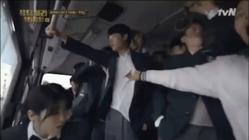 A Man In A Suit Is Being Held Up By A Group Of People In A Bus . GIF