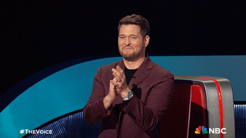 A Man In A Suit Is Clapping In Front Of A Nbc Sign GIF