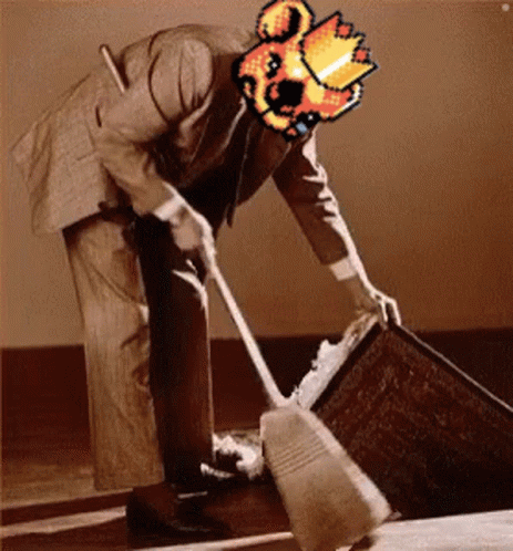 A Man In A Suit Is Cleaning The Floor With A Broom And Has A Pixelated Image Of A Fireball On His Head . GIF