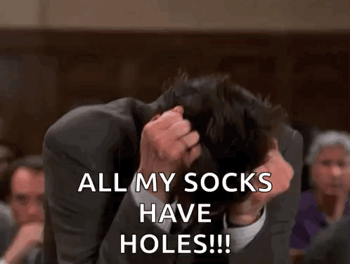 A Man In A Suit Is Covering His Face With His Hands And Saying `` All My Socks Have Holes ! '' GIF