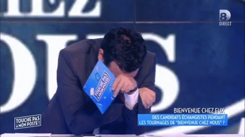 A Man In A Suit Is Crying While Holding A Book That Says Touche Pas Mon Poste GIF
