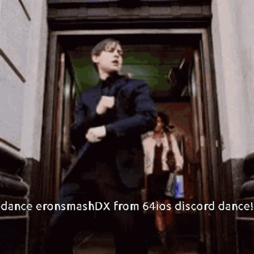 A Man In A Suit Is Dancing In A Doorway With The Words Dance Eronsmashdx From 64Ios Discord Dance GIF