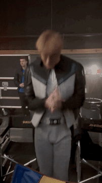 a man in a suit is dancing in front of a box that says guest