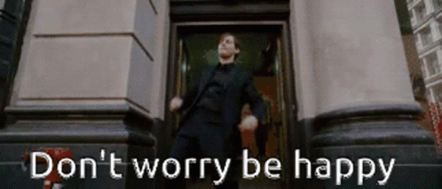 A Man In A Suit Is Dancing In Front Of A Building With The Words " Do N't Worry Be Happy " Written Below Him GIF