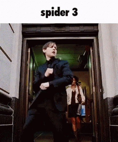 A Man In A Suit Is Dancing In Front Of A Door . GIF
