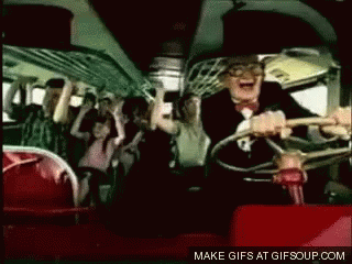 A Man In A Suit Is Driving A Bus With A Crowd Of People On It . GIF