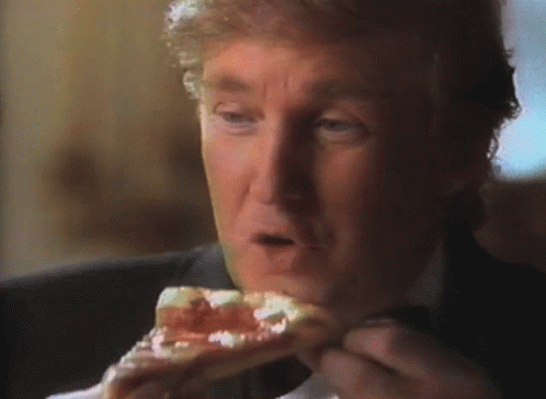 A Man In A Suit Is Eating A Piece Of Pizza GIF