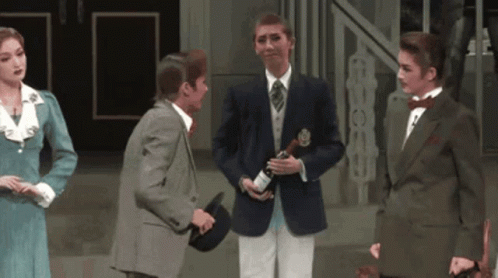 A Man In A Suit Is Holding A Bottle Of Champagne In His Hand GIF