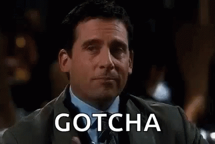 A Man In A Suit Is Holding A Glass Of Water And The Word Gotcha Is On The Screen Behind Him . GIF